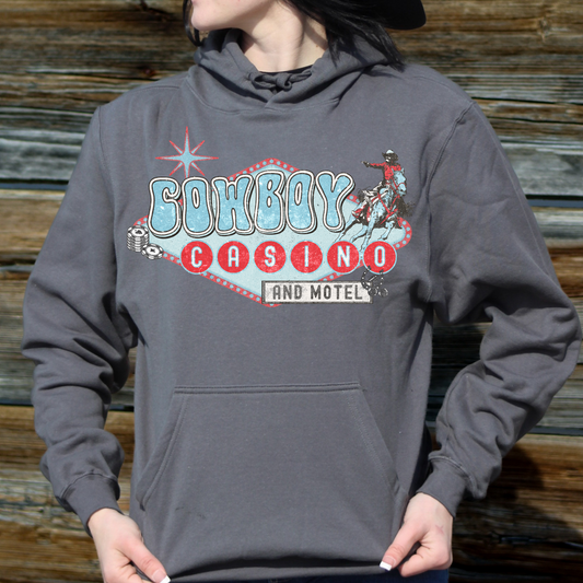 woman wearing charcoal colored hoodie with cowboy casino design on front.