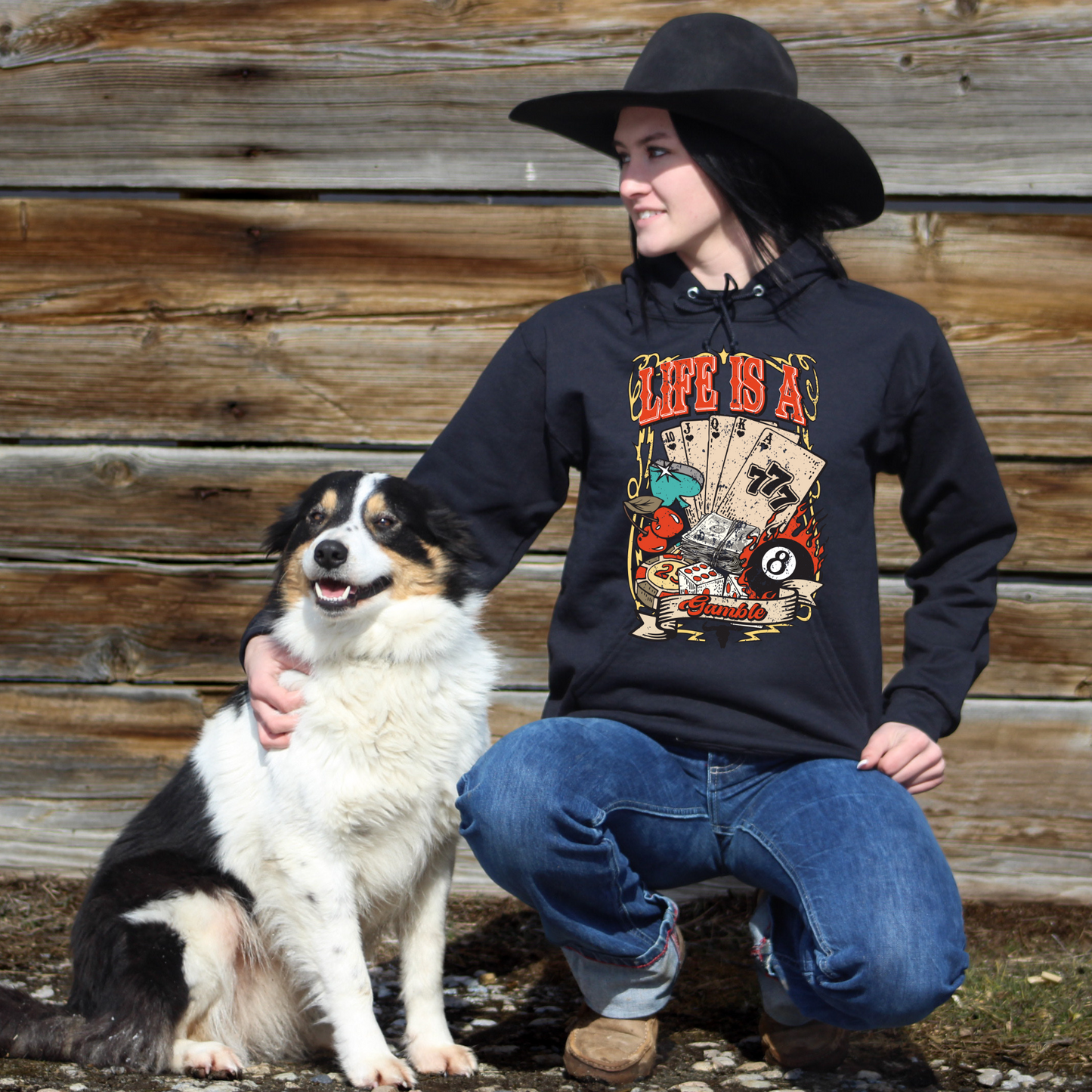 Woman petting dog wearing life is a gamble black hoodie